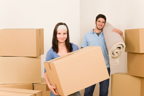 Movers carefully handling furniture on a residential street in Clapham Common